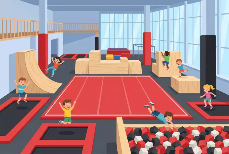 Illustration plate du Gravity Park de Meyrin : grand hall couvert avec tapis de gym rouge, blocs de parkour en bois clair, rampe courbe, trampolines à bordure rouge, fosse à mousse remplie de cubes rouges et noirs, et enfants qui sautent et grimpent