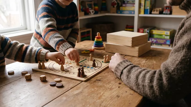 Mains d’enfants déplaçant des pions en bois sur un jeu de société posé sur une table de ludothèque, illustration IA