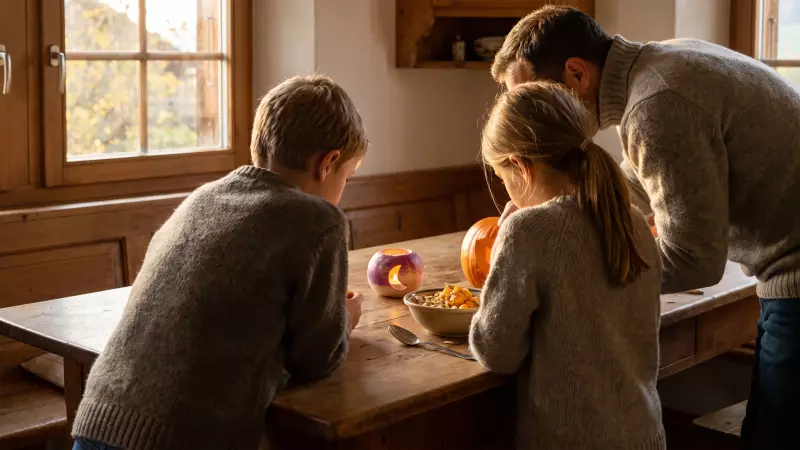 Un père et ses deux enfants, vus de dos, creusent une citrouille à côté d’un navet sculpté en lanterne sur une table de cuisine en bois