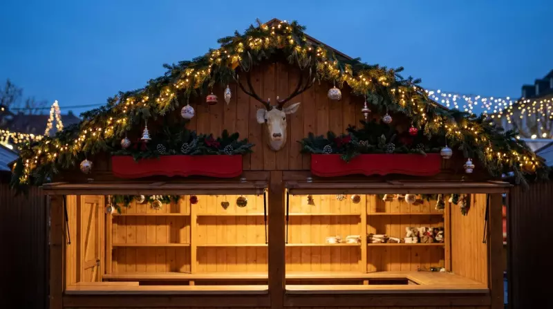Chalet du marché de Noël de Montreux au crépuscule, toit orné de guirlandes de sapin, de lumières et d'une tête de cerf
