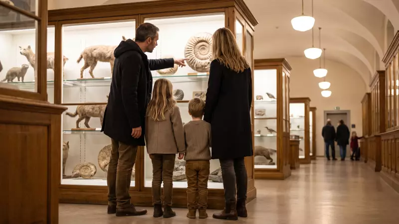 Deux enfants et leurs parents, vus de dos, observent une vitrine d’animaux et de fossiles dans un musée