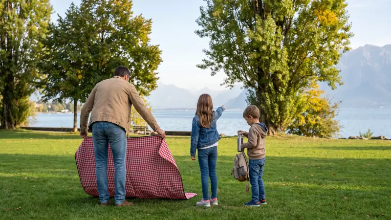 Une famille prépare un pique-nique au bord du Léman avec deux enfants à la fin de l’été